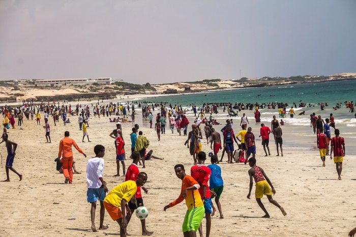 Young people playing football on a beach in Somalia
